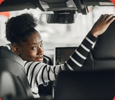 A passenger in the back seat looking over her shoulder and smiling